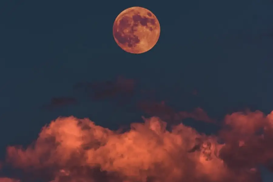 empathy pen poem - ominous reddish clouds at night with the moon in the sky - companion image to "The World's Reality" a poem by Oladipupo Gabriel Oluwamuyiwa - St. Louis