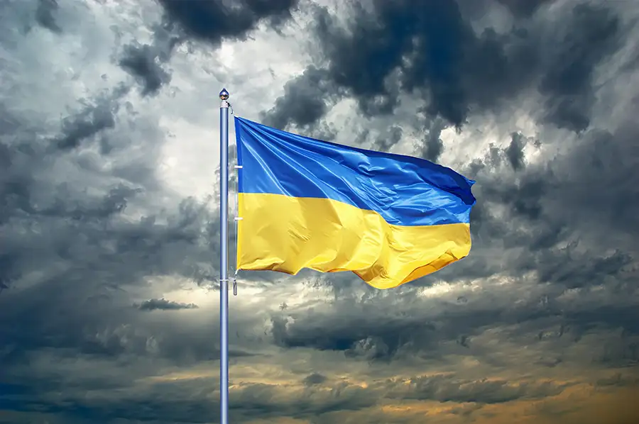 dark, ominous sky with billowing Ukrainian flag - companion image to "My Heart Bleeds" a poem by Gary Shulman, M.S. Ed. - St. Louis